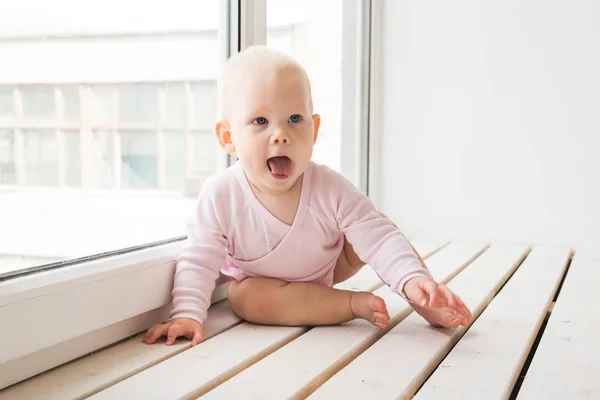 Barndom, familj och spädbarn koncept-Little Baby Girl på fönsterkarmen hemma — Stockfoto