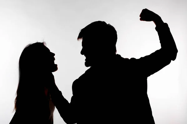 Domestic violence and abuse concept - Silhouette of man beating defenseless woman — Stock Photo, Image