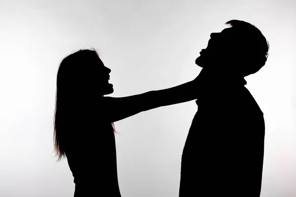 Domestic violence and abuse concept - Silhouette of a woman asphyxiating a man — Stock Photo, Image