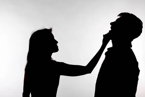 Aggression and abuse concept - man and woman expressing domestic violence in studio silhouette isolated on white background. — Stock Photo, Image