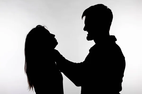 Domestic violence and abuse concept - Silhouette of a man asphyxiating a woman — Stock Photo, Image