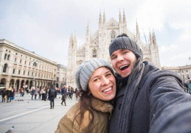 Milano Duomo Meydanı'nda güvercin ile kendi kendine portre çekici çift. Kış seyahat, İtalya ve ilişki kavramı