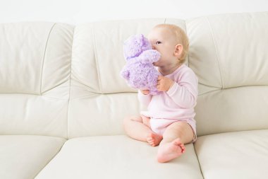 Çocuklar, bebek ve çocukluk konsepti - güzel gülümseyen bebek oturma