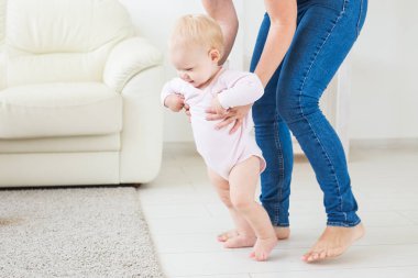 Evde anneler yardım ile ilk adımları atıyor Bebek