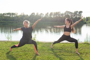 Sağlıklı yaşam tarzı ve uyum kavramı - Genç kızlar açık yoga yapıyor