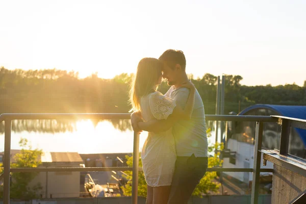 素晴らしい若いカップルは抱擁し、自然とバックライトの夕日に自然の屋外レジャー活動のライフスタイルと一緒に生活を楽しみます. — ストック写真