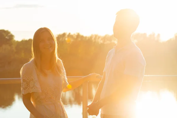 Wunderbare junge Paar umarmen und genießen das Leben zusammen mit natürlichen Outdoor-Freizeitaktivitäten Lebensstil in der Natur und den Sonnenuntergang im Gegenlicht. — Stockfoto