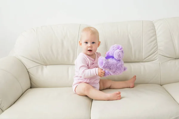 Concepto de niño, infancia y niños - Retrato de la encantadora niña en el sofá — Foto de Stock