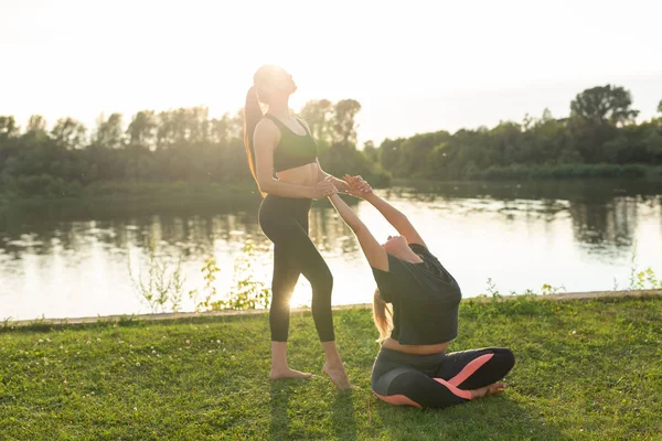 Piccolo gruppo di fitness femminile che fa yoga nel parco in una giornata di sole — Foto Stock