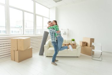 Denim pantolon genç çift hareket sırasında yeni dairede sevincini kucaklayan. Yeni konut için housewarming ve kredi kavramı.