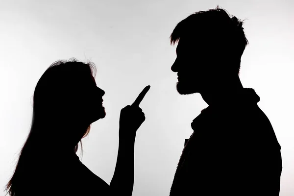 Aggression and abuse concept - man and woman expressing domestic violence in studio silhouette isolated on white background. — Stock Photo, Image