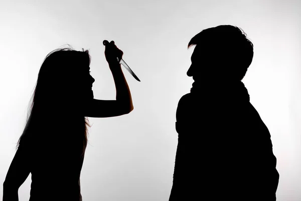 Koncepcja agresji i nadużyć-mężczyzna i kobieta wyrażająca przemoc domową w studio sylwetka na białym tle. — Zdjęcie stockowe