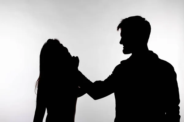 Concepto de agresión y abuso - hombre y mujer expresando violencia doméstica en silueta de estudio aislados sobre fondo blanco . — Foto de Stock