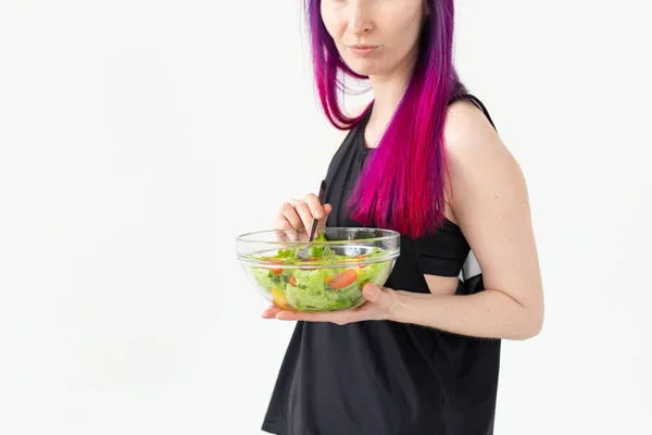 Gros plan de la jeune fille de remise en forme manger une salade de légumes légers après une séance d'entraînement à sa maison. Concept de perte de poids et mode de vie sain . — Photo