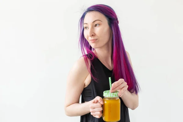 Rapariga não identificada hipster segurando um suco de proteína frutado com uma palha e fita métrica em fundo branco com espaço de cópia. Concepção de nutrição saudável e boa aptidão . — Fotografia de Stock