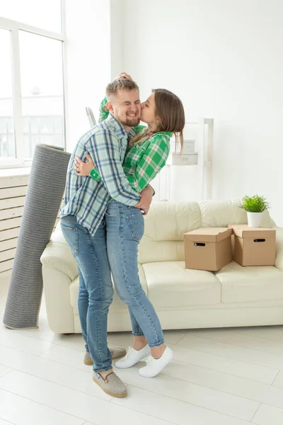 Liefdevolle jonge paar omarmen verheugen zich in de verhuizing naar hun nieuwe huis. Het concept van verhuizen en Inwijdingsfeest van jonge familie. — Stockfoto