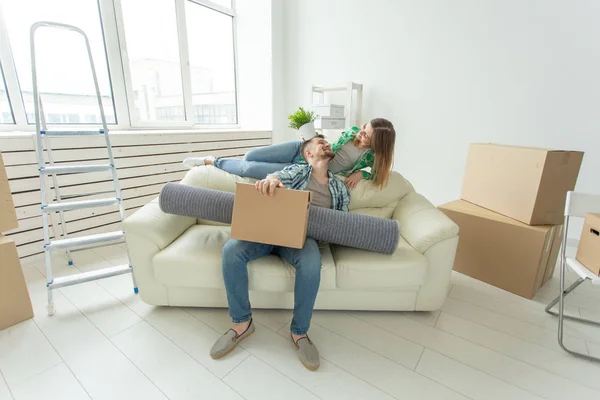 Neşeli genç çift oturma odasında eşyalarını koyarak yeni bir eve hareket etmek sevinler. Genç bir aile için ev ve ipotek konsepti — Stok fotoğraf