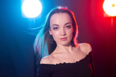 Gece kulübü, gece hayatı ve insan konsepti-karanlıkta poz veren genç kadın