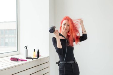 Kuaför, güzellik salonu ve insan kavramı - beyaz arka plan üzerinde saç kurutma makinesi ile genç kadın saç stilisti