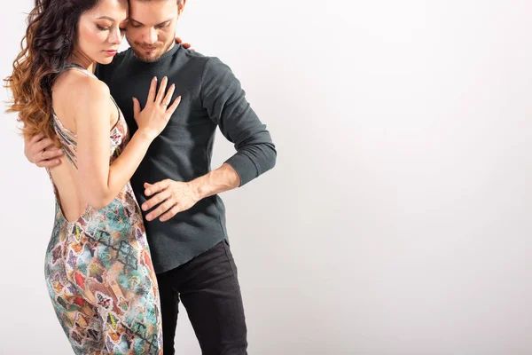 Young couple dancing latin dance bachata, merengue, salsa, kizomba. Two elegance pose over white background with copy space