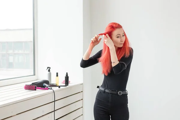 Schöne rothaarige Mädchen mit langen Haaren, sie ist webt einen Zopf, in einem Schönheitssalon. professionelle Haarpflege und Frisurengestaltung. — Stockfoto