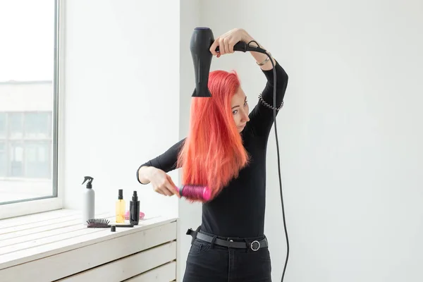 Парикмахер, стиль, люди концепции - женщина выдувает сухой ее цветные волосы — стоковое фото