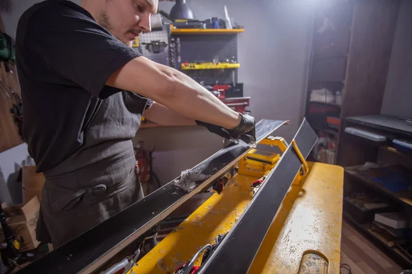 Een man reparman in workshop Ski Service repareren van de ski — Stockfoto