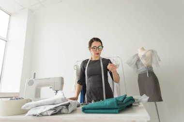 Terzi, moda tasarımcısı, terzi ve insanlar kavramı - iş yerinde bir kadın terzi portresi