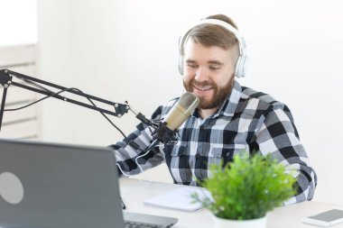 Bloglama, müzik ve yayın konsepti - radyo stüdyosunda genç erkek dj