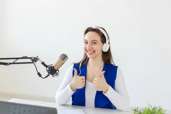 Radio, blogging, broadcast concept - Young woman working on the radio and showing thumbs up isolated on white background — Stock Photo, Image