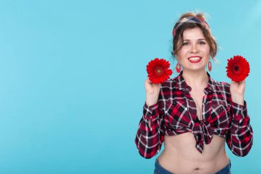 pin-up ve çiçek kavramı - kopya alanı ile mavi arka plan üzerinde gerberas ile güzel genç kadın