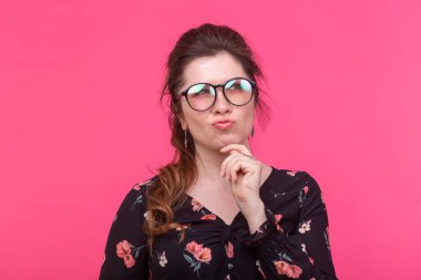 İş kadını ve öğrenci kavramı - Güzel akıllı düşünceli kız pembe arka plan üzerinden bakarak