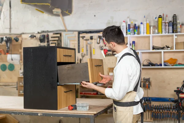 Meubelfabriek, kleine bedrijven en People concept-Young Man werkzaam bij de meubelproductie — Stockfoto