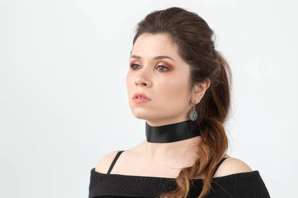 Close-up portrait of a charming pensive young beautiful woman in black clothes with a black ribbon around her neck. — Stock Photo, Image