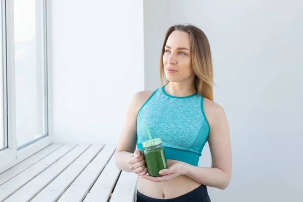 Saludable, dieta, desintoxicación y pérdida de peso concepto - mujer joven en ropa deportiva con batido verde —  Fotos de Stock