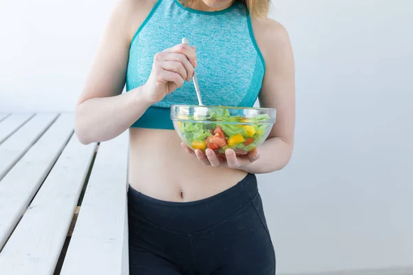Concetto sano, fitness e persone - Primo piano dell'insalata dietetica e della donna in abbigliamento sportivo — Foto Stock
