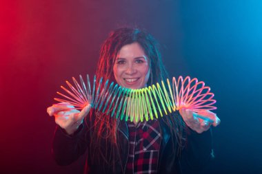 Ufa, Rusya - 3 Nisan 2019 : Elinde gökkuşağı oyuncak tutan gülümseyen büyüleyici genç esmer kadın. Kaygısız genç kız kavramı