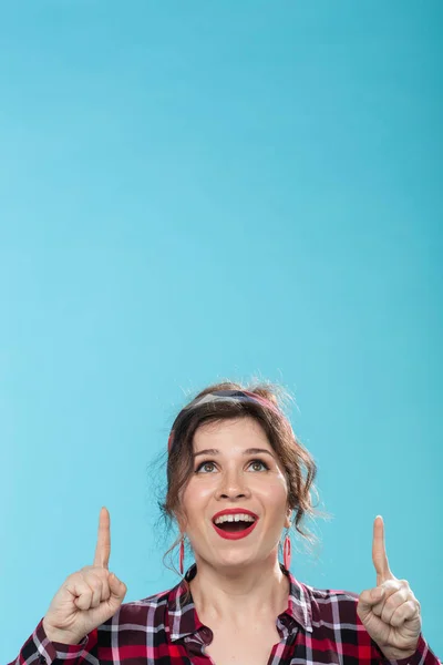 Concepto de moda y la gente - pin-up mujer mirando y apareciendo en el fondo azul — Foto de Stock