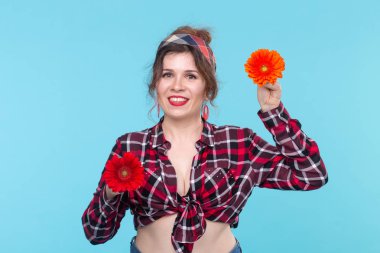 Yaz, pin-up ve eğlenceli kavram - mavi arka plan üzerinde gerberas ile güzel kadın