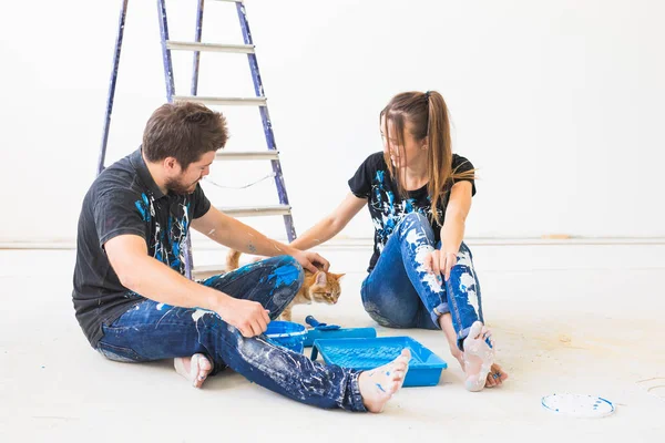 Reparação, pet, renovação e conceito de pessoas - casal com gato vai pintar a parede, eles estão misturando a cor — Fotografia de Stock