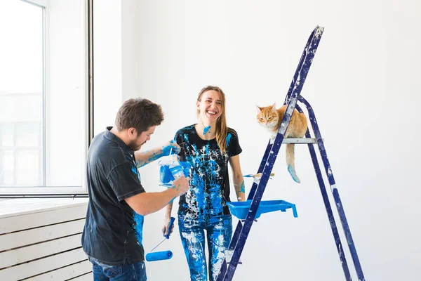 Evde beslenen hayvan, tadilat ve ilişki kavramı - yeni Daire Tadilat yapıyor kedi ile genç komik çift — Stok fotoğraf