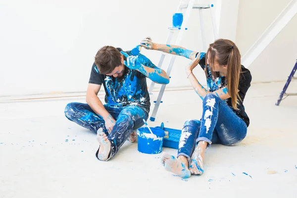 Rénovation, redécoration et concept de personnes - jeune couple faisant une rénovation dans une maison neuve et amusez-vous à la pause — Photo