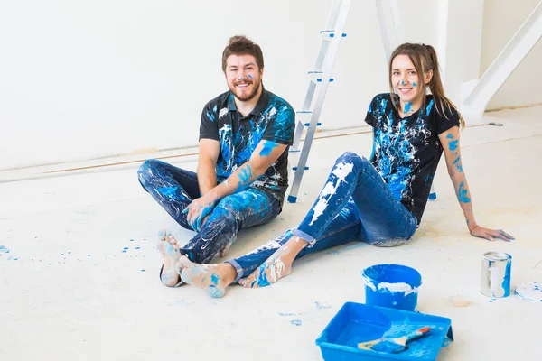 Ремонт, перепланировка и концепция людей - молодая пара делает ремонт в новом доме и веселится во время перерыва — стоковое фото
