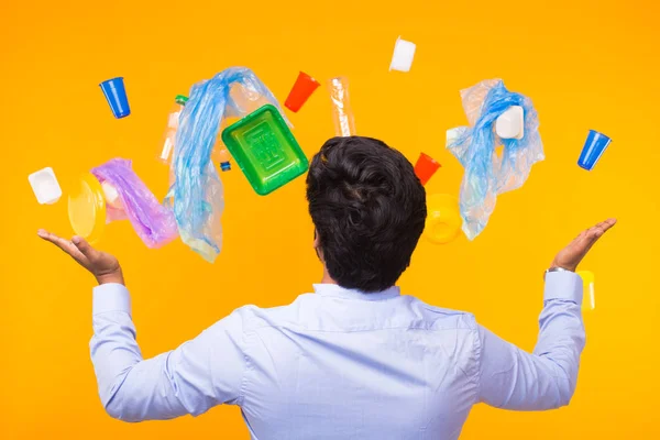 Problema del riciclaggio della plastica, ecologia e concetto di disastro ambientale - Vista posteriore dell'uomo indiano allarmato da un sacco di spazzatura su sfondo giallo — Foto Stock