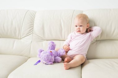 Çocuklar, bebek ve çocukluk konsepti - güzel gülümseyen bebek oturma