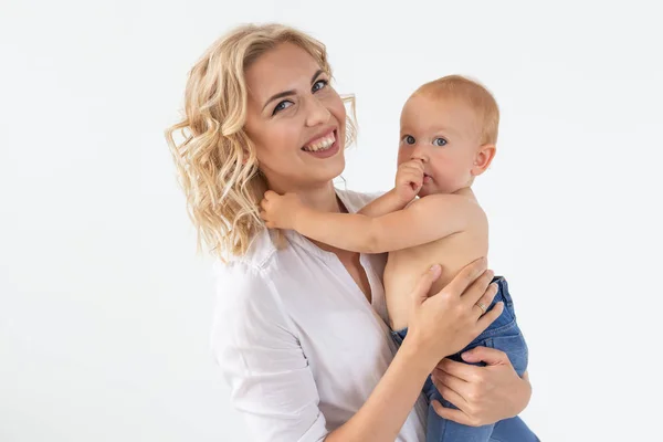Mãe feliz com bebê adorável no fundo branco — Fotografia de Stock
