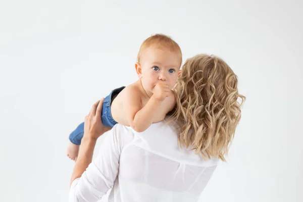 Madre soltera, maternidad y concepto de bebé - Alegre madre divirtiéndose con su hija pequeña en el estudio, aislada sobre fondo blanco — Foto de Stock