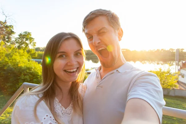 Bonito homem e jovem mulher se divertindo passar o tempo juntos e tomar selfie — Fotografia de Stock
