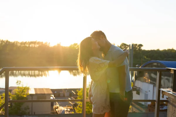 Uomo e donna che si abbracciano al tramonto sulla natura. Coppia in romantico abbraccio — Foto Stock