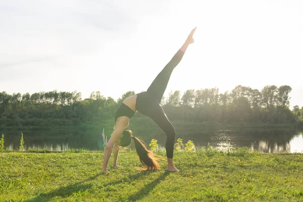 Güneşli bir günde parkta yoga yapan genç kadın